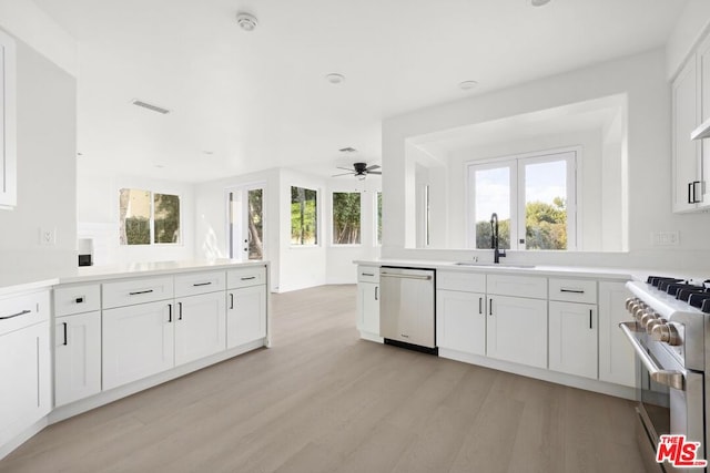 kitchen featuring white cabinetry, sink, ceiling fan, stainless steel appliances, and light wood-type flooring