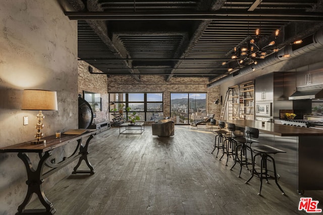 dining space with a towering ceiling and hardwood / wood-style floors