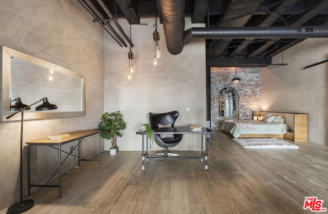 bedroom featuring hardwood / wood-style floors and a high ceiling