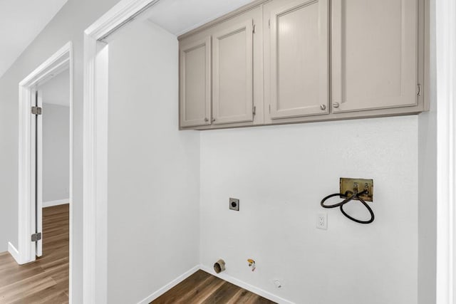 clothes washing area with dark wood-type flooring, cabinets, electric dryer hookup, washer hookup, and hookup for a gas dryer