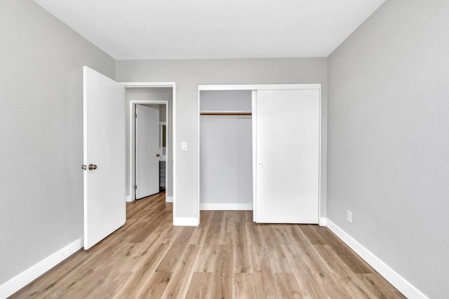 unfurnished bedroom with a closet and light wood-type flooring