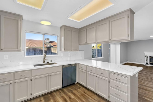 kitchen with sink, dark hardwood / wood-style flooring, kitchen peninsula, dishwasher, and decorative backsplash