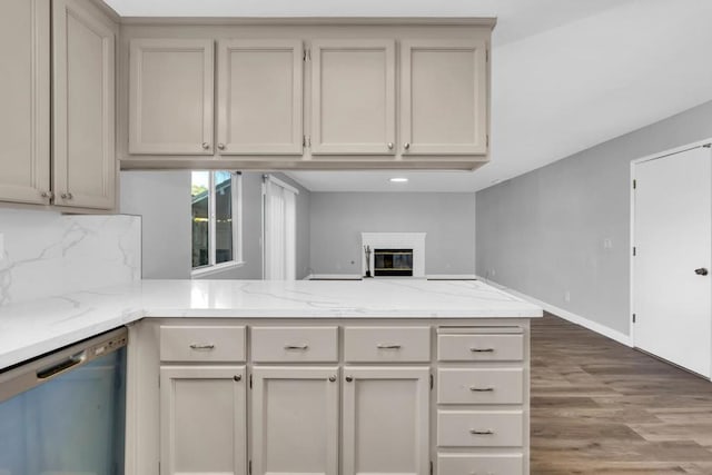 kitchen with hardwood / wood-style floors, decorative backsplash, stainless steel dishwasher, and kitchen peninsula