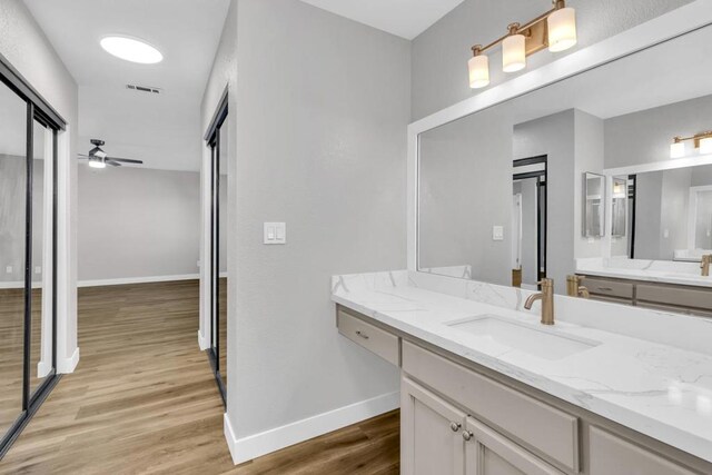 bathroom featuring hardwood / wood-style flooring, ceiling fan, and vanity