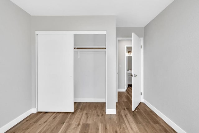 unfurnished bedroom with a closet and light wood-type flooring