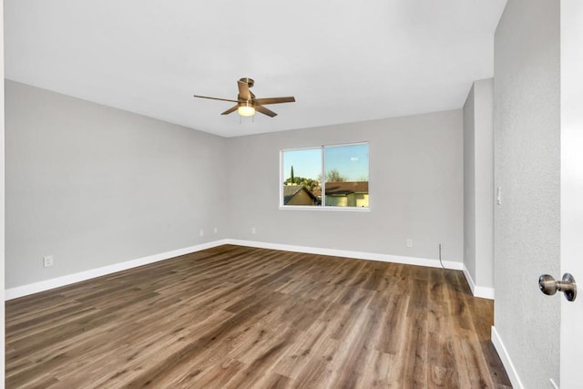 empty room featuring dark wood-type flooring and ceiling fan