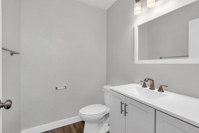 bathroom with vanity, toilet, and hardwood / wood-style floors