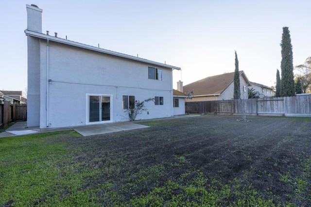 rear view of property featuring a patio and a lawn