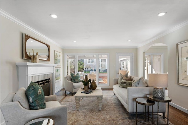 living room featuring ornamental molding, a brick fireplace, and dark wood-type flooring