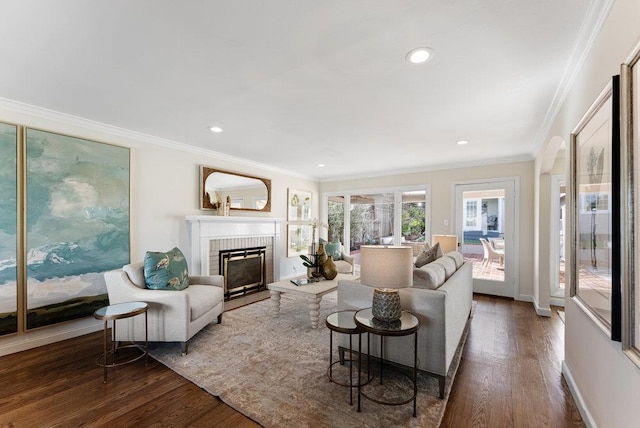 living room with ornamental molding, a fireplace, and dark hardwood / wood-style flooring