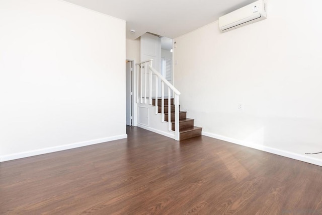 empty room featuring dark hardwood / wood-style flooring and a wall mounted AC