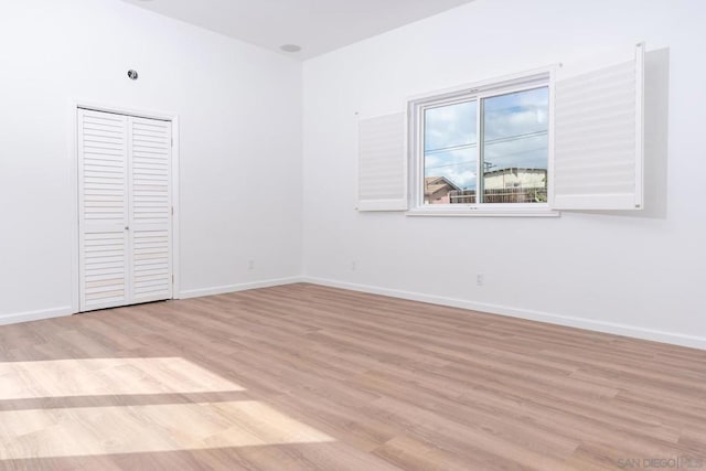 unfurnished bedroom with a closet and light wood-type flooring