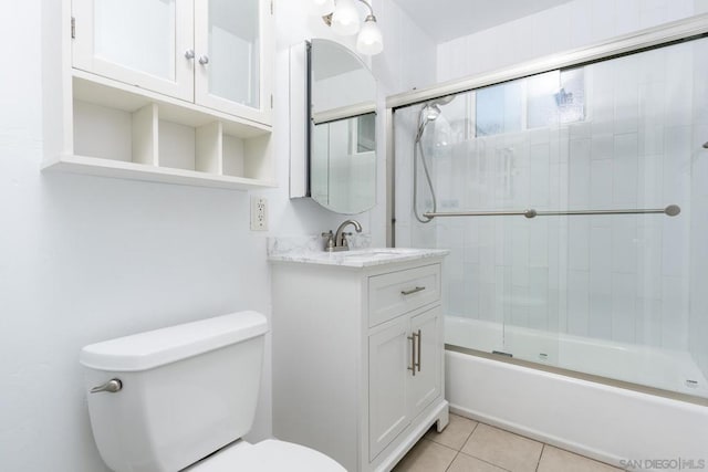 full bathroom with toilet, tile patterned floors, bath / shower combo with glass door, and vanity