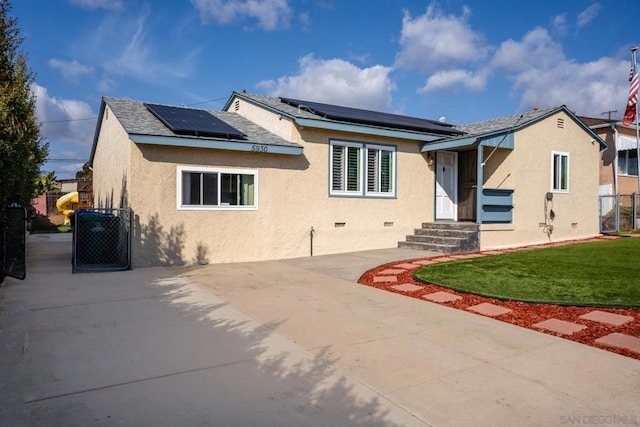 view of front facade featuring a front lawn and solar panels