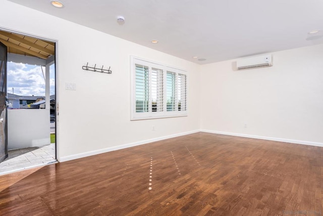 empty room with hardwood / wood-style floors and a wall unit AC