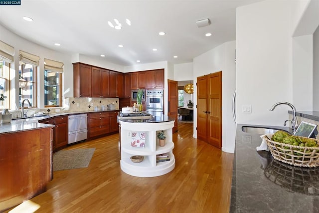 kitchen with stainless steel appliances, sink, and light wood-type flooring