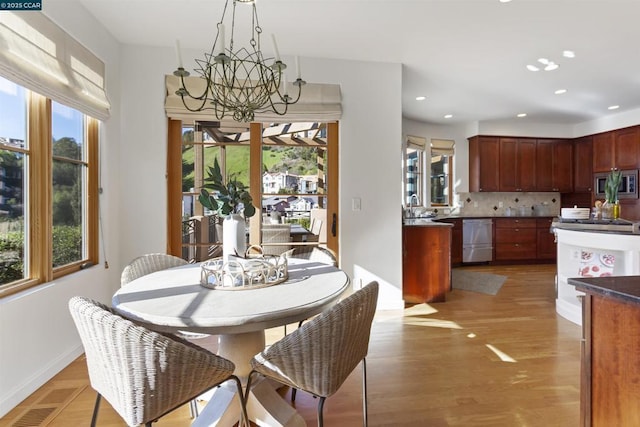 dining room with an inviting chandelier and light hardwood / wood-style flooring