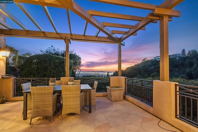 patio terrace at dusk featuring a pergola