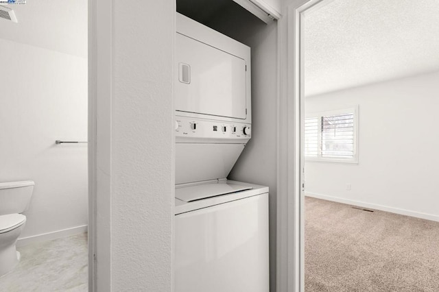 washroom featuring light colored carpet and stacked washing maching and dryer