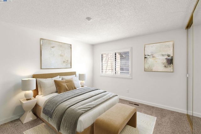 bedroom with carpet and a textured ceiling