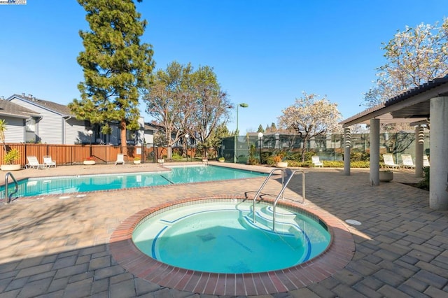 view of swimming pool featuring a patio and a community hot tub