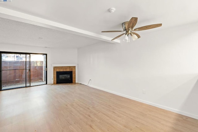 unfurnished living room featuring ceiling fan, a fireplace, and light hardwood / wood-style flooring