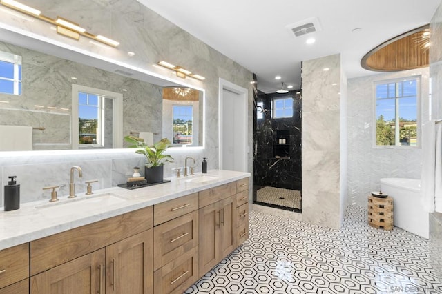 bathroom featuring tile patterned floors, vanity, an enclosed shower, and tile walls