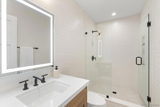 bathroom featuring vanity, an enclosed shower, and toilet