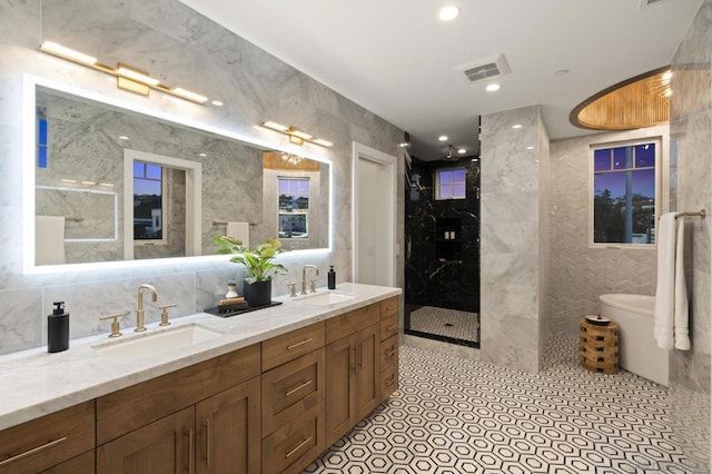 bathroom featuring tile walls, backsplash, tiled shower, vanity, and tile patterned floors