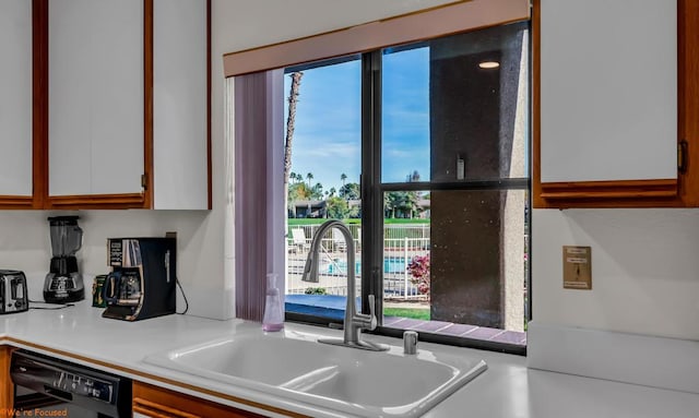 kitchen with dishwasher, sink, and white cabinets