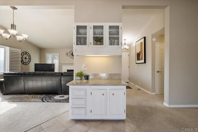 kitchen featuring white cabinetry, light colored carpet, a chandelier, and hanging light fixtures