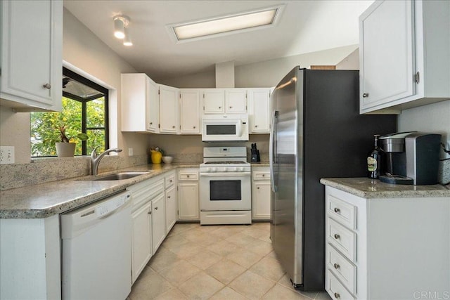 kitchen with vaulted ceiling, white appliances, sink, and white cabinets