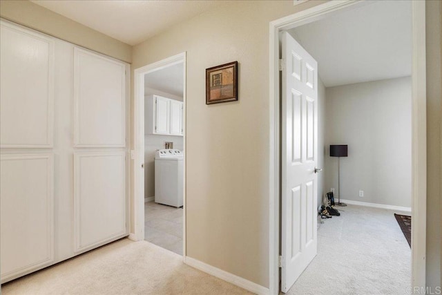 corridor featuring light colored carpet and washer / clothes dryer