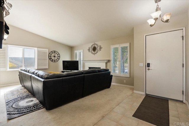 carpeted living room with a fireplace, a chandelier, and vaulted ceiling