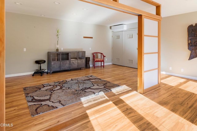 interior space featuring an AC wall unit and light wood-type flooring