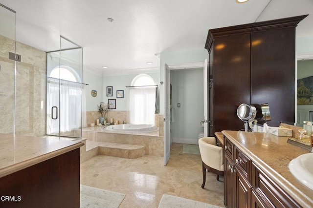 bathroom with ornamental molding, vanity, and shower with separate bathtub