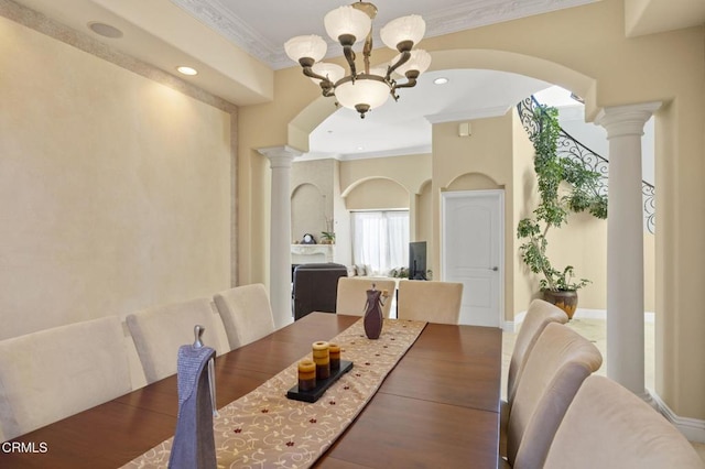 dining space with ornamental molding, decorative columns, and a notable chandelier