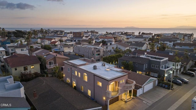 aerial view at dusk featuring a water view