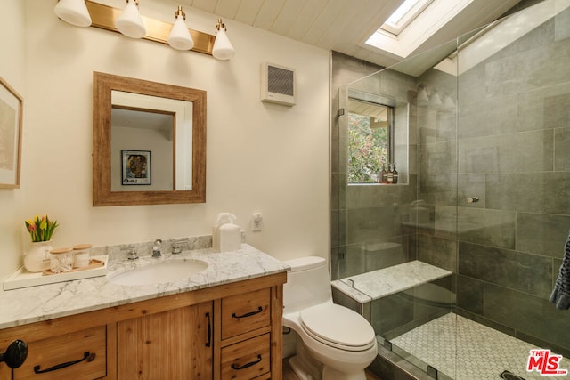 bathroom with vanity, an enclosed shower, lofted ceiling with skylight, and toilet