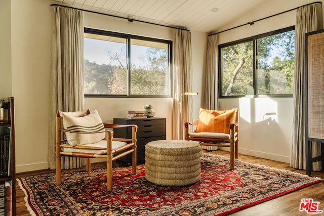 living area featuring hardwood / wood-style flooring and vaulted ceiling