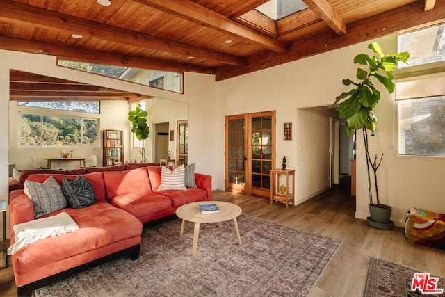 living room featuring a skylight, beamed ceiling, light hardwood / wood-style floors, wooden ceiling, and french doors