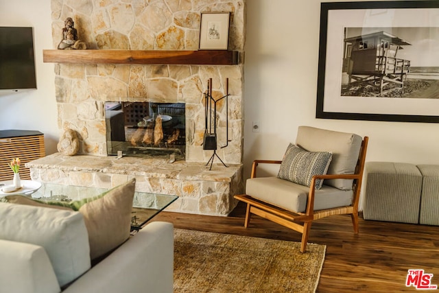 living room featuring dark hardwood / wood-style floors, radiator heating unit, and a fireplace