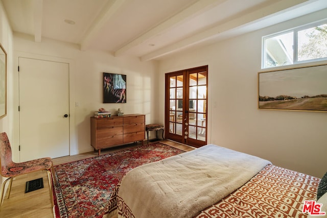 bedroom featuring beam ceiling and french doors