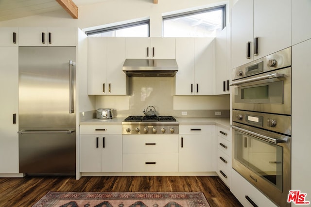 kitchen featuring white cabinetry, appliances with stainless steel finishes, dark hardwood / wood-style flooring, and extractor fan