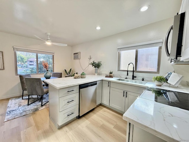 kitchen featuring sink, white cabinets, stainless steel dishwasher, light stone counters, and kitchen peninsula