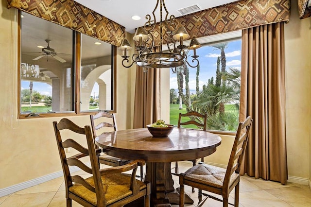 dining room featuring ceiling fan with notable chandelier, plenty of natural light, and light tile patterned floors