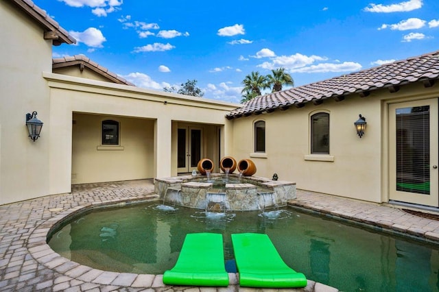 view of pool featuring a jacuzzi, a patio area, and pool water feature