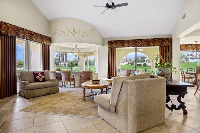 living room featuring vaulted ceiling, ceiling fan with notable chandelier, and light tile patterned floors