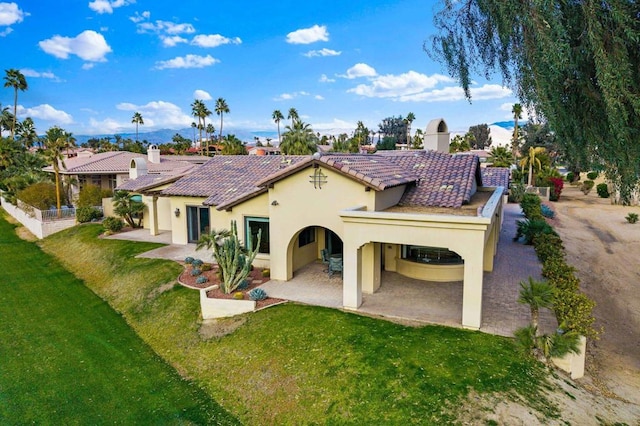 back of house featuring a patio and a yard