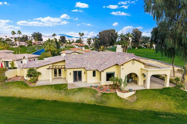 back of house with a yard and a patio